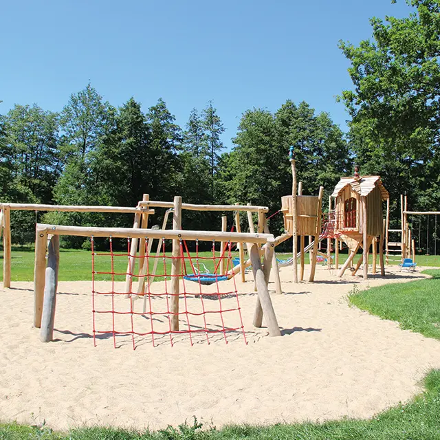 Kinderspielplatz aus Holz, mit Schaukeln und Klettergerüst