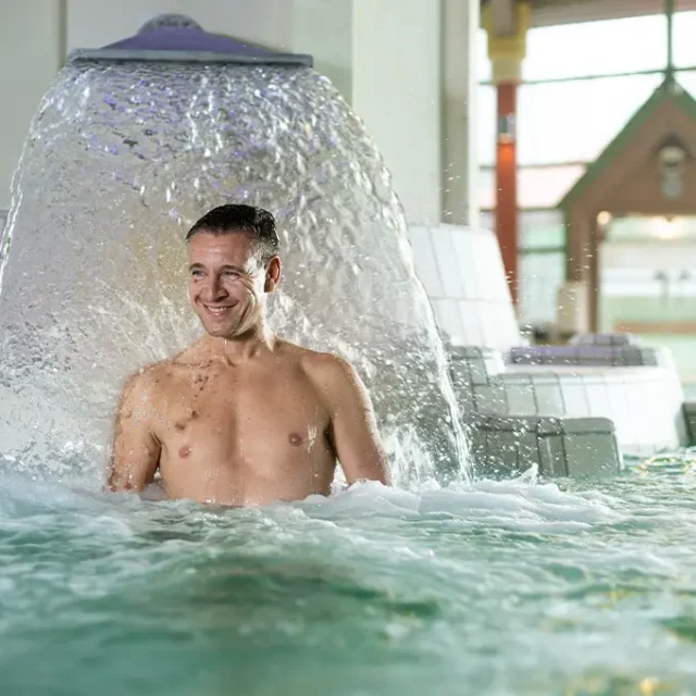 Mann steht unter einer Nackendusche