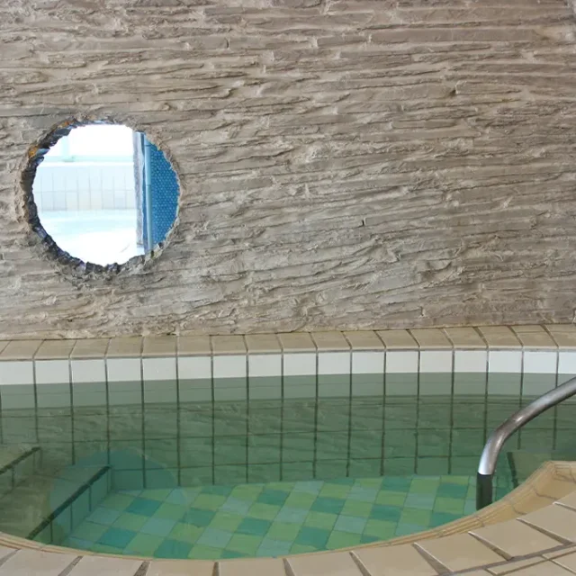 Treppen mit Haltegriff führen in ein Kalttauchbecken