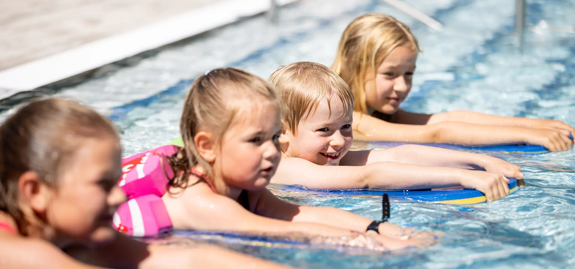 Einen Gruppe von Kindern mit Schwimmhilfen im Wasser