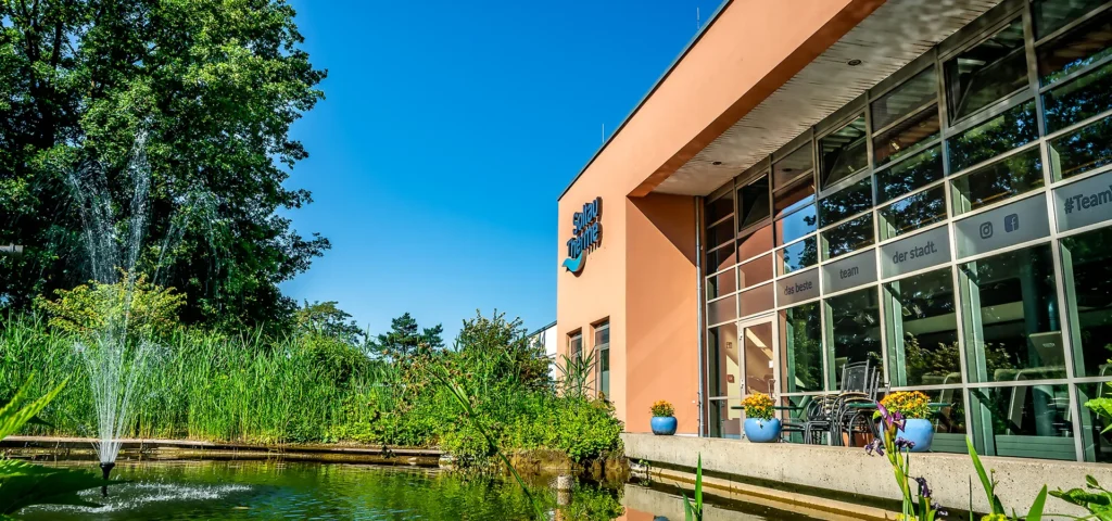 Außenansicht mit Bäumen und Soltau Therme Logo an der Fassade