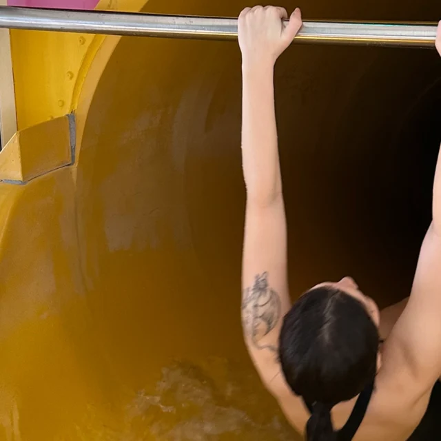 Eine Frau rutscht in einer gelben Rutsche