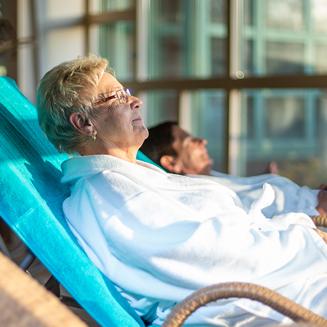 Ältere Dame liegt in der Sonne im Raum des Gradierwerks