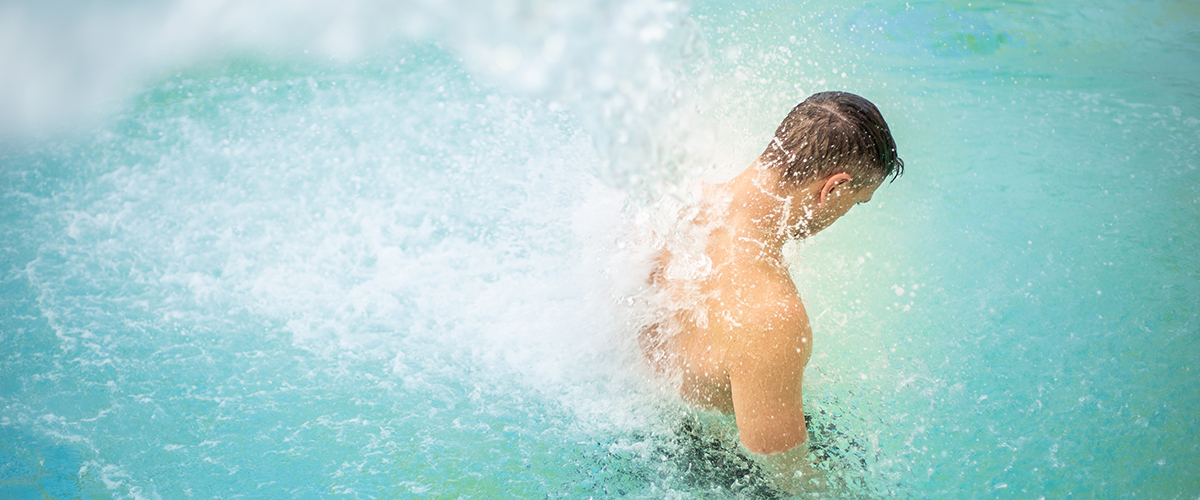 Mann steht im Wasserfall der Sole