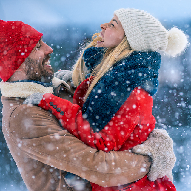 Glückliches Paar umarmt sich im Schnee
